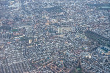 Londra 'nın kenar mahallelerinin havadan görünüşü, sabahın erken saatlerinde İngiltere' nin sanayi bölgesi yakınlarında altın saat gündoğumu bulutları arasında.