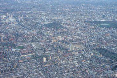 Londra 'nın kenar mahallelerinin havadan görünüşü, sabahın erken saatlerinde İngiltere' nin sanayi bölgesi yakınlarında altın saat gündoğumu bulutları arasında.