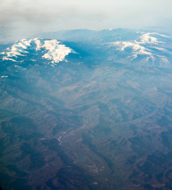 Avrupa 'da karla kaplı dağ zirvesi gökyüzünden izleniyor, bir dağ manzarası.