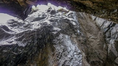 İsviçre, Meiringen, Schwarzwaldalp, karla kaplı bir dağın yamacında ağaçlarla dolu bir şelale.