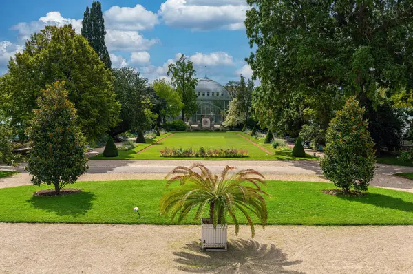 French garden of the Jardin des Serres dAuteuil with a Greenhouse in the background. This botanical gaden is a public park located in Paris, France