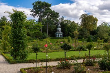 Bagatelle parkında arka planda imparatoriçe büfesi olan gül bahçesi. Paris, Fransa yakınlarındaki Boulogne-Billancourt 'da yer almaktadır.