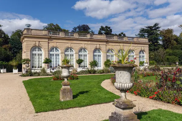 Stock image Boulogne-Billancourt, France - August 13 2023: Orangerie in the Bagatelle park with the rose garden in the foreground. It was built in 1835. It is located in Boulogne-Billancourt near Paris, France