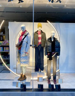 Bracknell, İngiltere - 23 Ocak 2025: Bir sonraki moda perakende mağazasının vitrininde kadınlar için kış giysileri ve ayakkabıları sergileniyor.