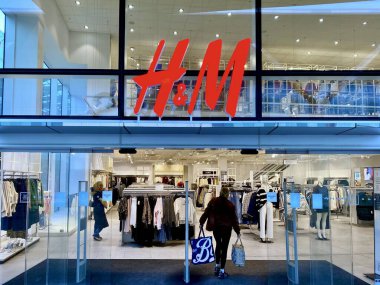 Bracknell, İngiltere - 09 Ocak 2025: H & M moda mağazasının sabah erken saatlerde girişi ve vitrininde bir kişi dükkana giriyor.