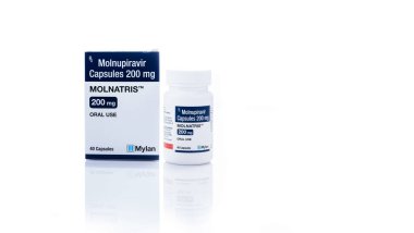 CHONBURI, THAILAND-OCTOBER 17, 2022: Molnupiravir kapsülleri 200 mg ilaç şişesi ve tedavi için karton kutu ambalajı covid-19. Molnatris, Merck lisansı altında Mylan Laboratuvarları tarafından üretildi. 