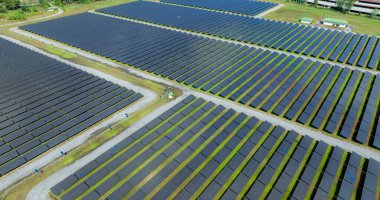 Güneş çiftliğinin havadan görünüşü. Yeşil enerji için güneş enerjisi. Sürdürülebilir kaynaklar. Güneş pili panelleri elektrik üretmek için güneş ışığını kaynak olarak kullanır. Fotovoltaik ya da PV. Sürdürülebilir yenilenebilir enerji.