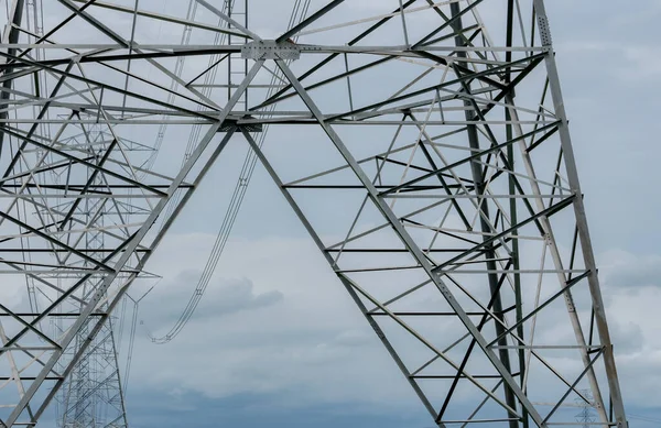 High voltage electric transmission tower. High voltage power lines against blue sky. Electricity pylon and electric power transmission lines. High Voltage tower provide power supply. Power and energy.