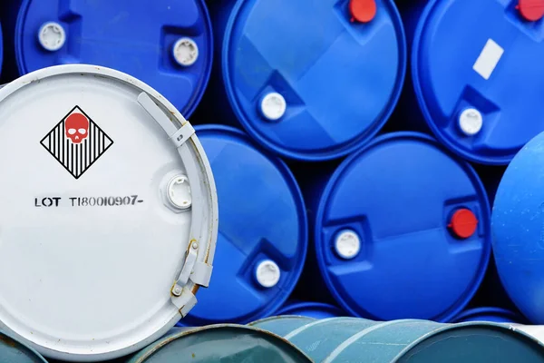 Old chemical barrels. Blue and green oil drum. Steel and plastic oil tank. Toxic waste warehouse. Hazard chemical barrel with warning label. Industrial waste in drum. Hazard waste storage in factory.