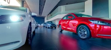 Car parked in luxury showroom. Car dealership office. New red car parked in modern showroom. Auto for sale and rent business concept. Automobile leasing and insurance concept. Car dealer company