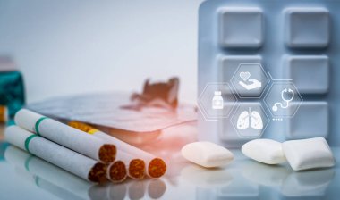 Sigarayı bırak ya da nikotin terapisi ya da NRT ile sigarayı bırak. 31 Mayıs Dünya Tütün Yok Günü. Sigara yığınının yanında nikotin sakızı. Sigarayı durdurmak için nikotin ürünleri.