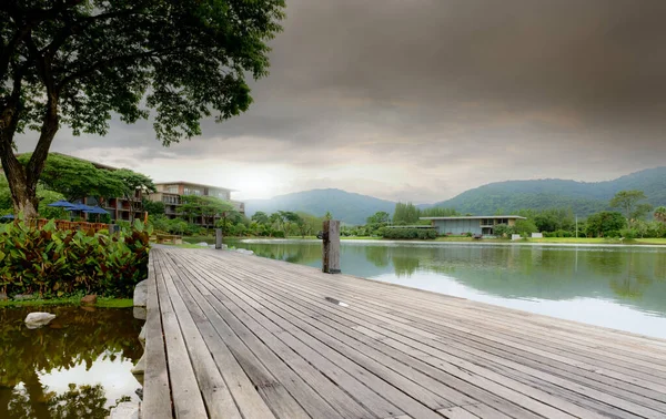 Wooden bridge at the lake in a sustainable hotel near the mountain. Luxury hotel in the forest. Green luxury hotel in the valley. Nature retreat. Lakefront hotel. Travel destinations for retreat mind.