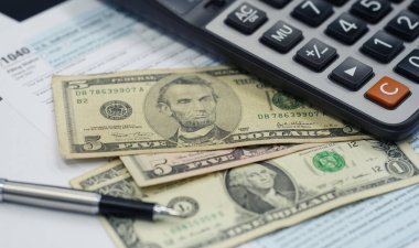 Tax season concept. Tax planning and consulting service business. Pen, calculator, dollar banknote, and income tax return form for filling and calculating tax payments. Money and financial concept. 