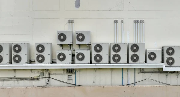 stock image Many condensing units of air conditioners are installed on concrete building wall. Air conditioner maintenance and repair service at home or office. AC maintenance. Air compressor outside building.