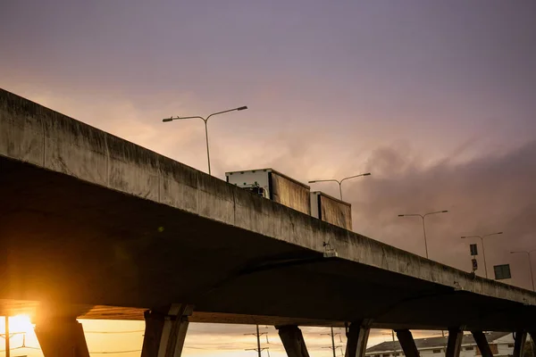 用卡车驾驶的高架混凝土公路的底部视图 过混凝土路 公路天桥结构 日落时分的高速公路 混凝土桥梁工程建设 桥梁建筑 — 图库照片