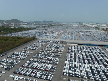 Fabrika otoparkındaki yeni arabaların hava görüntüsü. Arka arkaya park edilmiş manzaralı arabaların üstünde. Otomotiv endüstrisi. Lojistik işi. Depoya yeni araba ithal et veya ihraç et. Liman terminalindeki büyük otopark.