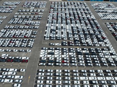 Fabrika otoparkındaki yeni arabaların hava görüntüsü. Arka arkaya park edilmiş manzaralı arabaların üstünde. Otomotiv endüstrisi. Lojistik işi. Depoya yeni araba ithal et veya ihraç et. Liman terminalindeki büyük otopark.