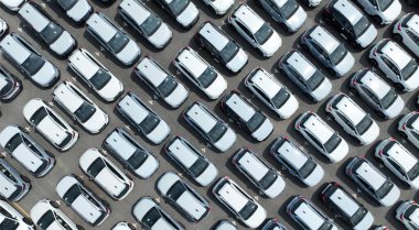 Fabrika otoparkındaki yeni arabaların hava görüntüsü. Arka arkaya park edilmiş manzaralı arabaların üstünde. Otomotiv endüstrisi. Lojistik işi. Depoya yeni araba ithal et veya ihraç et. Liman terminalindeki büyük otopark.