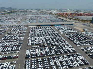 Fabrika otoparkındaki yeni arabaların hava görüntüsü. Arka arkaya park edilmiş manzaralı arabaların üstünde. Otomotiv endüstrisi. Lojistik işi. Depoya yeni araba ithal et veya ihraç et. Liman terminalindeki büyük otopark.