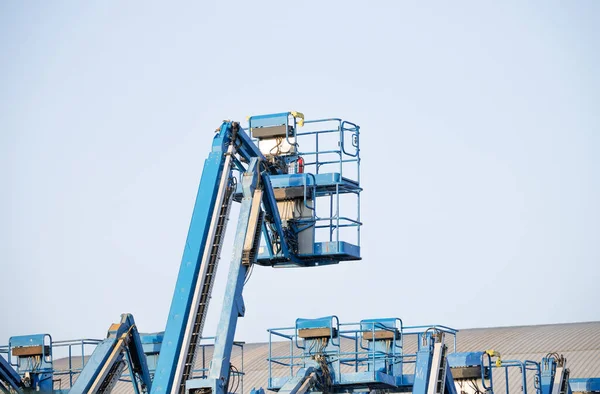 stock image Articulated boom lift. Aerial platform lift. Telescopic boom lift against clear sky. Mobile construction crane for rent and sale. Maintenance and repair hydraulic boom lift service. Crane dealership.