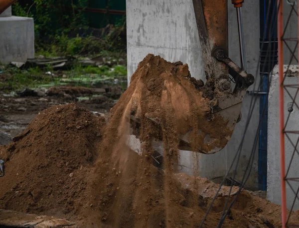 建設現場で土を掘ることによって働くバックホウ バックホー砂を掘るのバケツの歯 土中を掘削するクローラー掘削機 掘削機だ 地球人の機械だ 発掘車両 道路補修 — ストック写真
