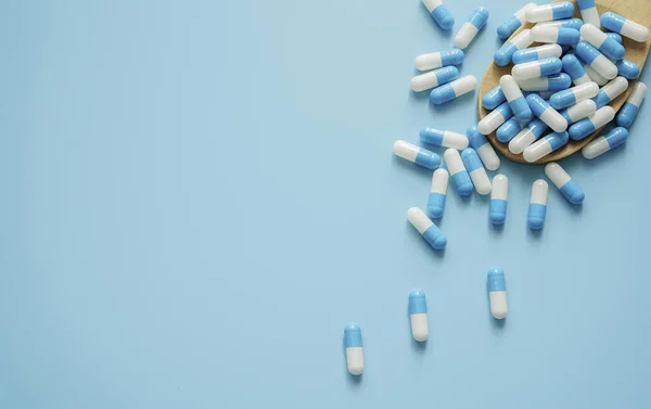 Modrobílá Antibiotická Pilulka Dřevěná Lžička Modrém Pozadí Prášky Rámeček Prostorem — Stock fotografie