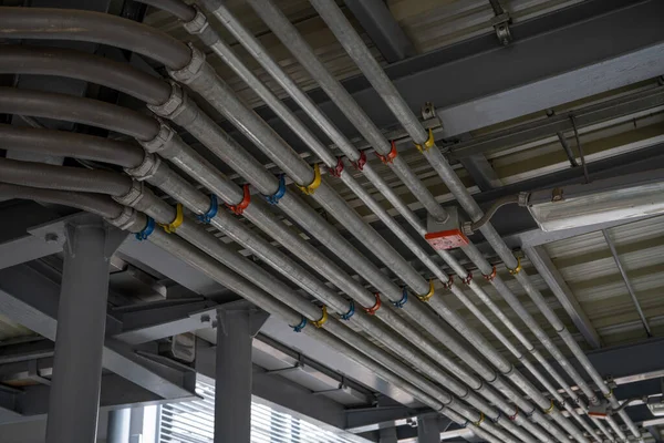 建物の天井に取付けられている電気コンジット システムおよび管 産業インフラ 有効な電気配線の取付けおよび管理 コンジットシステム ストックフォト
