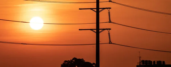 High voltage electric transmission pylon. High voltage power lines against sunset sky. Electricity pylon and electric power transmission lines. High Voltage pole provide power supply. Energy crisis.