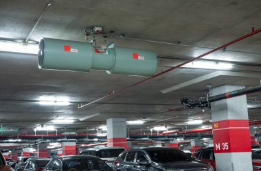 Jet fan at underground parking area. Ventilation fan in the parking lot. Air flow system. Ventilation system in underground car parking lot at commercial building. Duct fan air ventilation at mall.