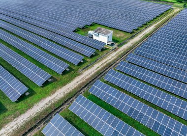 Güneş çiftliğinin havadan görünüşü. Yeşil enerji için güneş enerjisi. Sürdürülebilir kaynaklar. Güneş pili panelleri elektrik üretmek için güneş ışığını kaynak olarak kullanır. Fotovoltaik ya da PV. Sürdürülebilir yenilenebilir enerji.