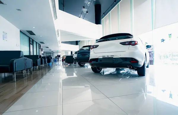 Rearview car parked in luxury showroom. Car dealership office. New car parked in modern showroom. Car for sale and rent business concept. Automobile leasing and insurance concept. Electric automobile.