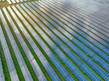 Güneş çiftliğinin havadan görünüşü. Yeşil enerji için güneş enerjisi. Sürdürülebilir kaynaklar. Güneş pili panelleri elektrik üretmek için güneş ışığını kaynak olarak kullanır. Fotovoltaik ya da PV. Sürdürülebilir yenilenebilir enerji.