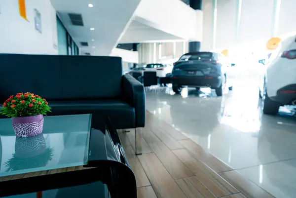 Blurred car parked in luxury showroom.  Car dealership office. New car parked in modern showroom. Automobile leasing and insurance background. Auto leasing business. Electric vehicle. Reception area.