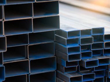 İnşaat malzemeleri ve inşaat malzemeleri için sanayi deposu dikdörtgen metal borular. Çelik borular yığını. İnşaat ve altyapı projeleri için demir malzemeler. Çelik boru deposu.