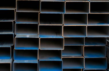 İnşaat malzemeleri ve inşaat malzemeleri için sanayi deposu dikdörtgen metal borular. Çelik borular yığını. İnşaat ve altyapı projeleri için demir malzemeler. Çelik boru deposu.