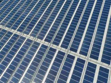 Endüstriyel fabrikanın çatısındaki güneş panelleri. Fabrika ya da depo için güneş enerjisi. Ticari güneş enerjisi. Sanayi fotovoltaik panelleri. Çatıdaki güneş enerjisi. Yeşil enerji. Sürdürülebilir enerji.