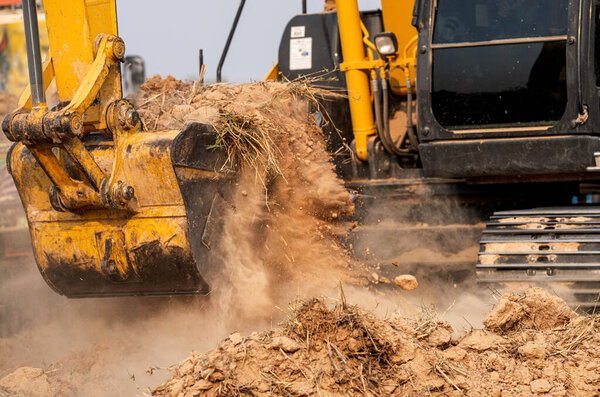 Closeup bucket of backhoe digging the soil at construction site. Crawler excavator digging on demolition site. Excavating machine. Earth moving equipment. Excavation vehicle. Construction business.