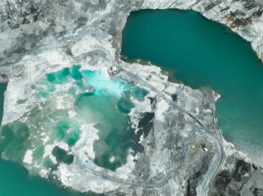 Açık maden endüstrisi. Kireç taşı ocağı kepçe ve kamyon çalışıyor. Madencilik endüstrisinde ve inşaat malzemelerinde ağır makineler. Endüstriyel bir bölgede kaynak çıkarma manzarası