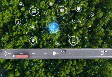 Yeşil orman otoyolu boyunca uçan hava manzaralı sürücüsüz araba ve hidrojenle çalışan kamyon. Elektrikli araçlarla sürdürülebilir ulaşım ve çevre dostu çevrede yenilenebilir enerji.