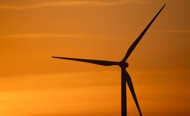 Gün batımına karşı rüzgar türbini silueti. Rüzgar gücü. Sürdürülebilir yenilenebilir enerji üretimi. Çevre dostu enerji üretimi ve çevresel koruma için yeşil teknoloji. Doğal manzara..