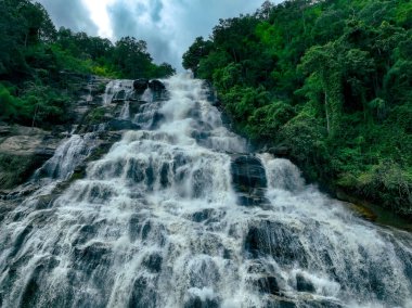 Doi Inthanon Ulusal Parkı, Chiang Mai, Tayland 'daki yemyeşil bir ormandaki şelalenin havadan görünüşü. Bu doğa manzarası su sürdürülebilirliğini ve manzaralı seyahat noktalarını gösteriyor..