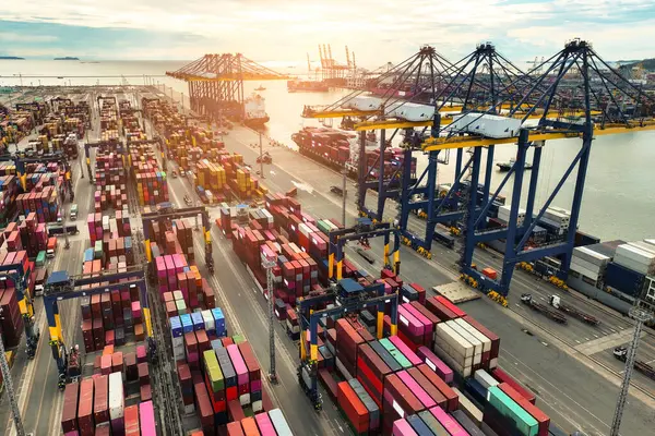 Konteynır gemisi kargo kamyonları ve vinçlerle limana yanaştı. Küresel lojistik merkezi. Denizcilik nakliye operasyonları. Uluslararası ticaret ve tedarik zinciri yönetimi. İthalat-ihracat terminali. Küresel ticaret.