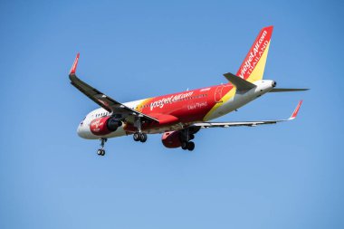 SAMUT PRAKAN, THAILAND-Kasım 12, 2024: Vietjet ticari uçağı gökyüzünde uçuyor. Uluslararası bir havaalanına iniyor. Hava taşımacılığı, havacılık endüstrisi ve küresel ulaşım ağları.