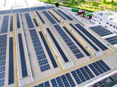 Yükleme limanlarında yük kamyonları olan güneş enerjili depo tesisi. Çevre dostu lojistik ve verimli kargo taşımacılığı. Dağıtım merkezinde güneş panelleri ve sürdürülebilir enerji kavramı.