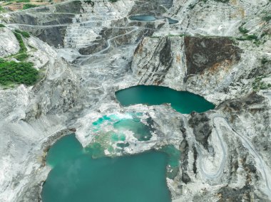 Açık maden endüstrisi. Kireç taşı ocağı kepçe ve kamyon çalışıyor. Madencilik endüstrisinde ve inşaat malzemelerinde ağır makineler. Endüstriyel bir bölgede kaynak çıkarma manzarası