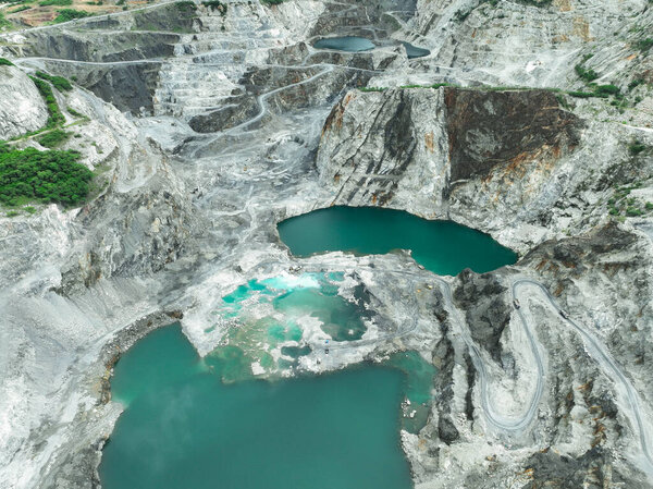 Открытая горнодобывающая промышленность. Известняковый карьер с экскаватором и грузовиком в эксплуатации. Тяжелое машиностроение в горнодобывающей промышленности и поставке строительных материалов. Пейзаж добычи ресурсов на промышленной площадке