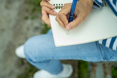Defterde açık havada bir kadının el yazısı var. Özdeğerlendirme, hedef belirleme, günlük tutma alışkanlığı ve dikkatli planlama. Yaratıcılık, hayat planlaması ve kişisel gelişime odaklanmak. Dikkatli bir uygulama..