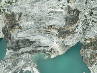 Açık maden endüstrisi. Kireç taşı ocağı kepçe ve kamyon çalışıyor. Madencilik endüstrisinde ve inşaat malzemelerinde ağır makineler. Endüstriyel bir bölgede kaynak çıkarma manzarası