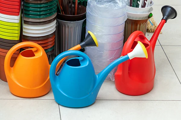 市場で販売されているプラスチックカラフルな散水缶ガーデニングツール — ストック写真
