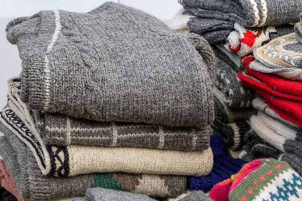 Stack  of  folded warm winter woollen sweaters sold on market